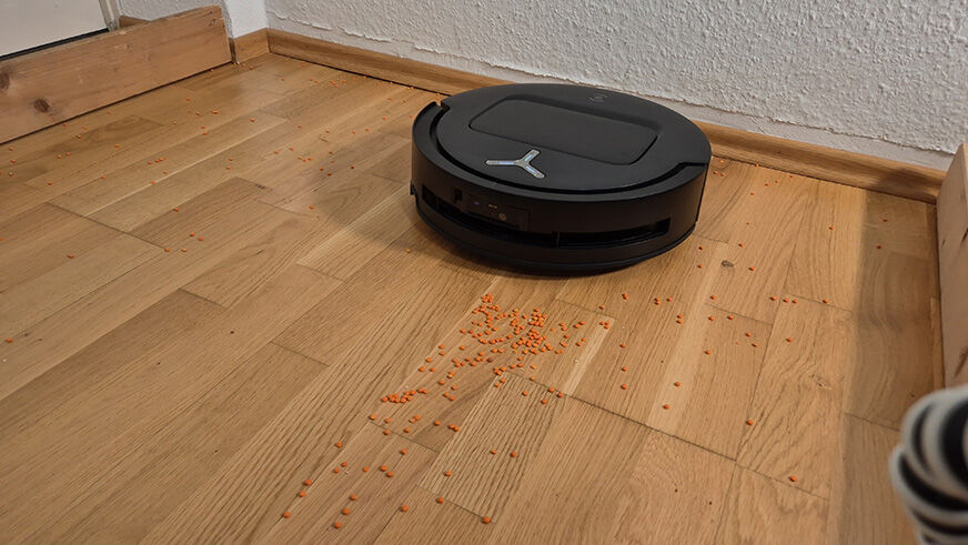 Der ECOVACS DEEBOT T80 OMNI entfernt Linsen, auf Hartboden.